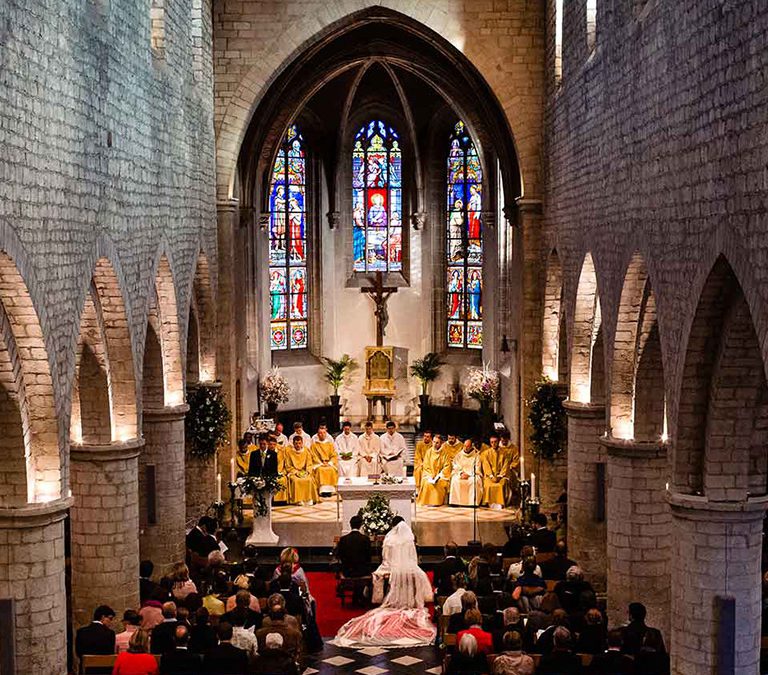 Photographe de mariage à Dijon, photographie une vue plongeante dans un église avec vue sur les invitées et les mariées