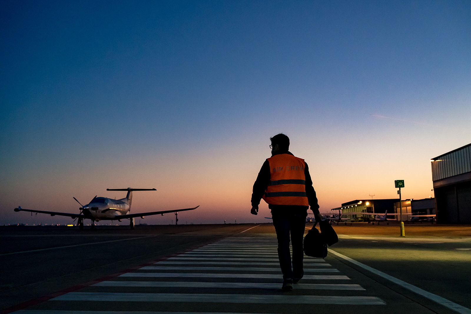 pilote se rends a pied vers son avion, aéroport Charleroi au lever du soleil