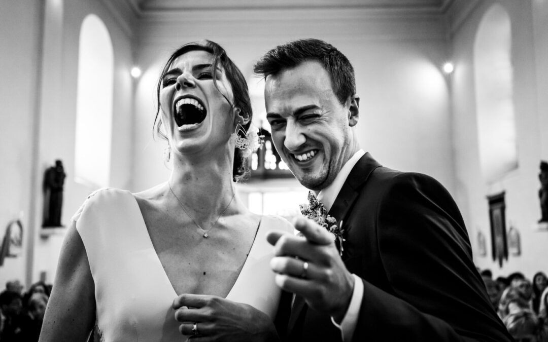 Un couple de mariés rigolent lors leur mariage, dans l'église du Hof ten Steen à Linter.
