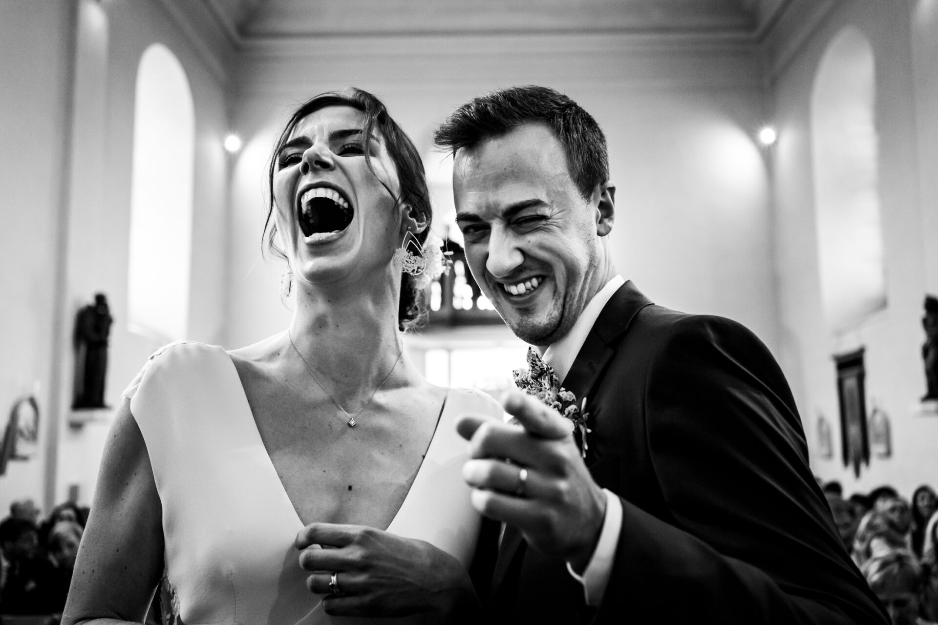 Un couple de mariés rigolent lors leur mariage, dans l'église du Hof ten Steen à Linter.