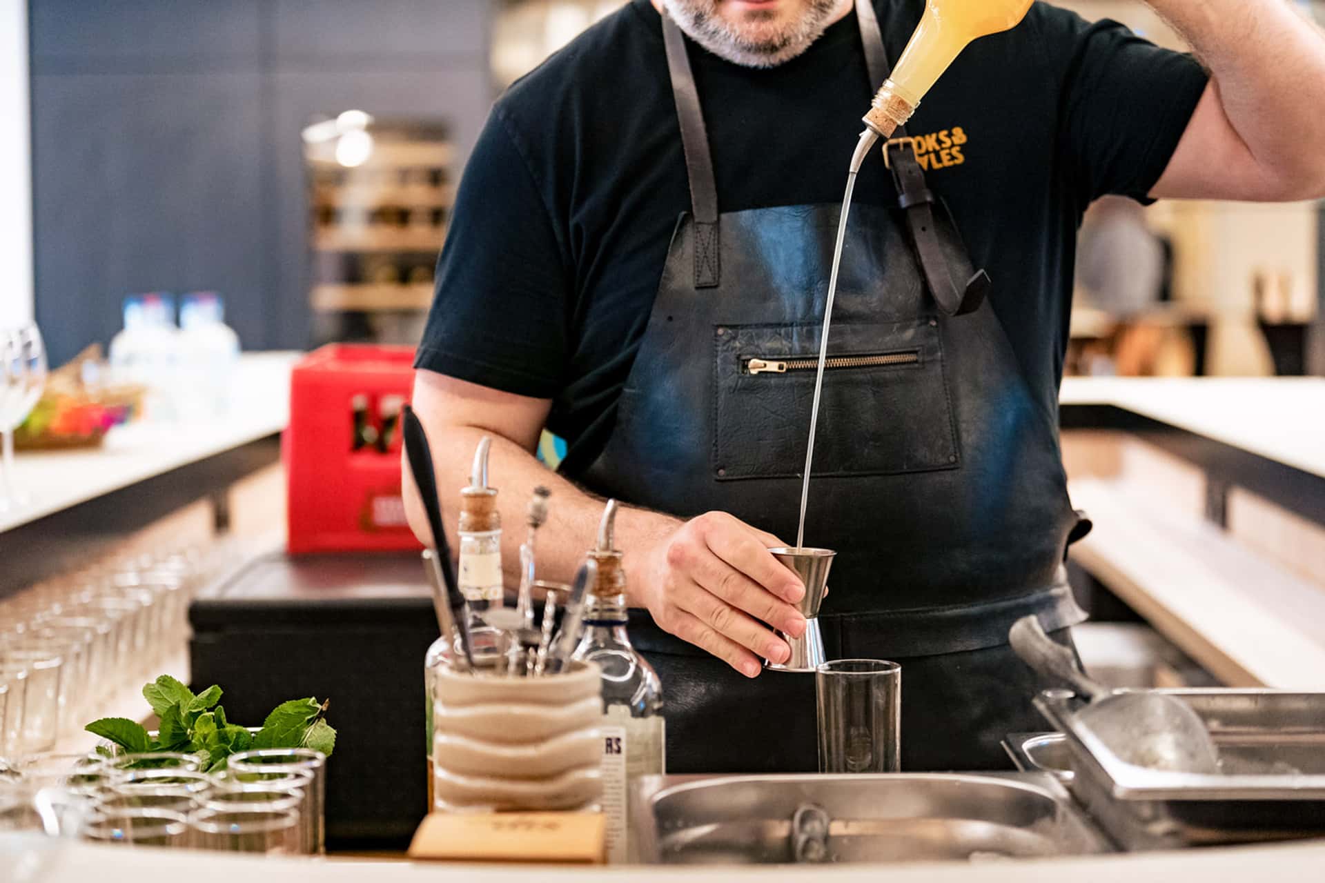 Barman fait des cocktail avec du gin et de la menthe lors d'un événement corporate chez Cushman & Wakefield