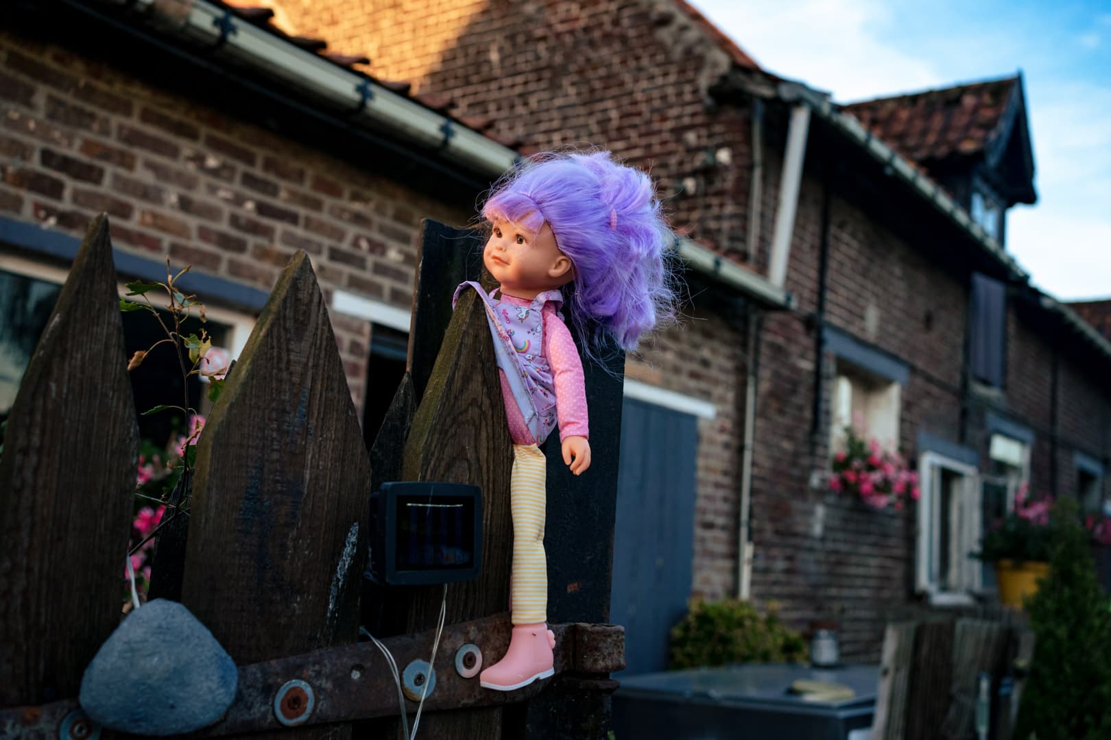 Petite poupée accrochée à une pointe d'une barrière en bois d'une ferme.