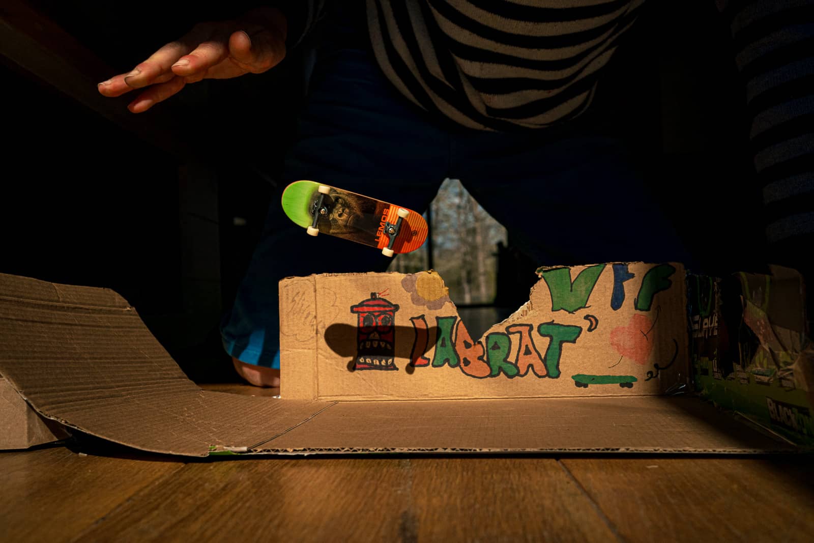 Un miniskate en l'air après un trip d'un garçon du Brabant Wallon dans un skateparc fait en carton.