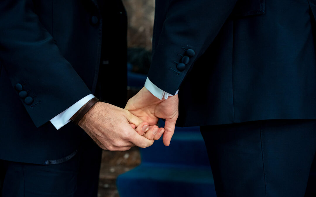 Close-up des mains de deux mariés gay se tenant la main avant leur mariage à Bruxelles