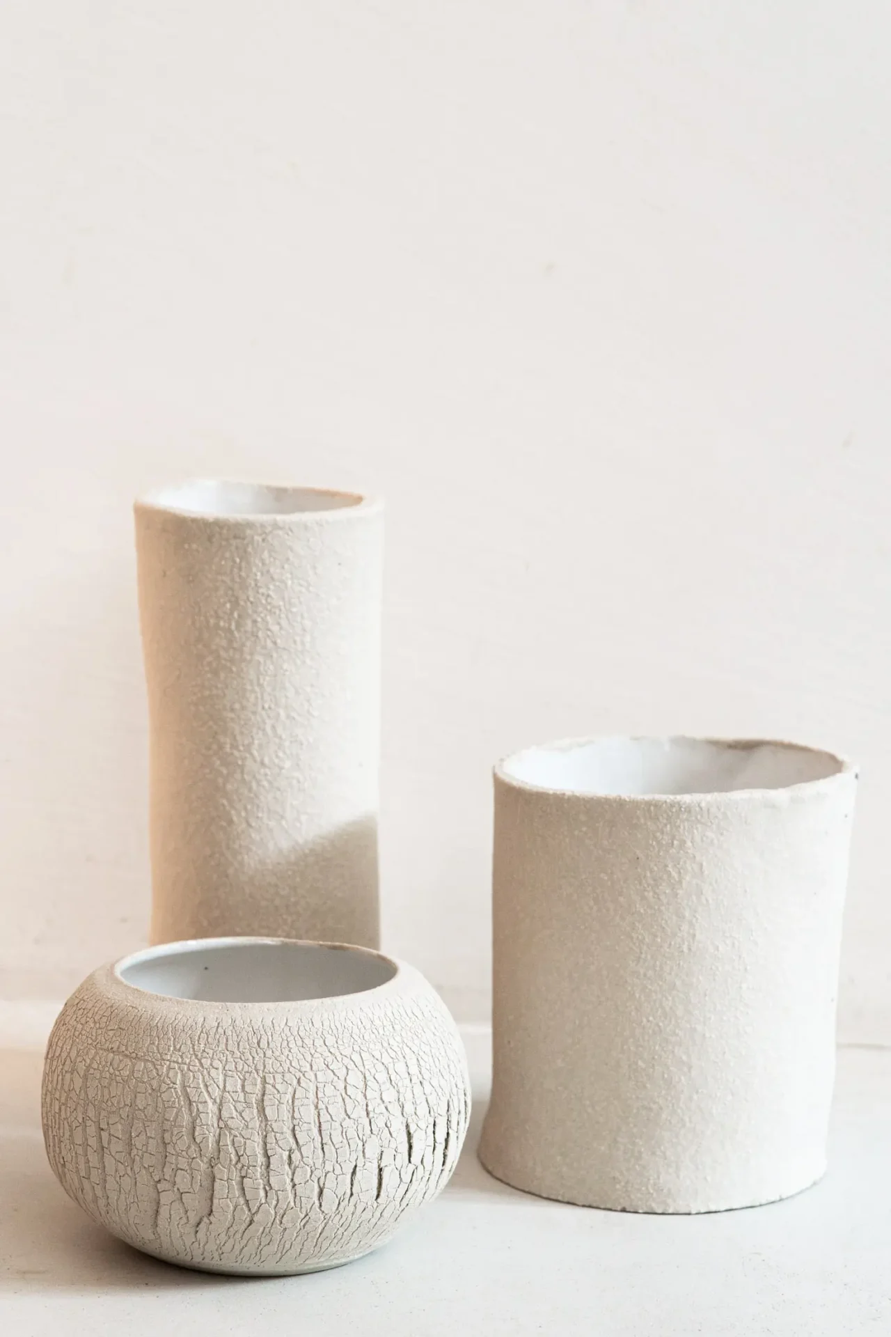 Trois vases en céramique blanc sur fond blanc