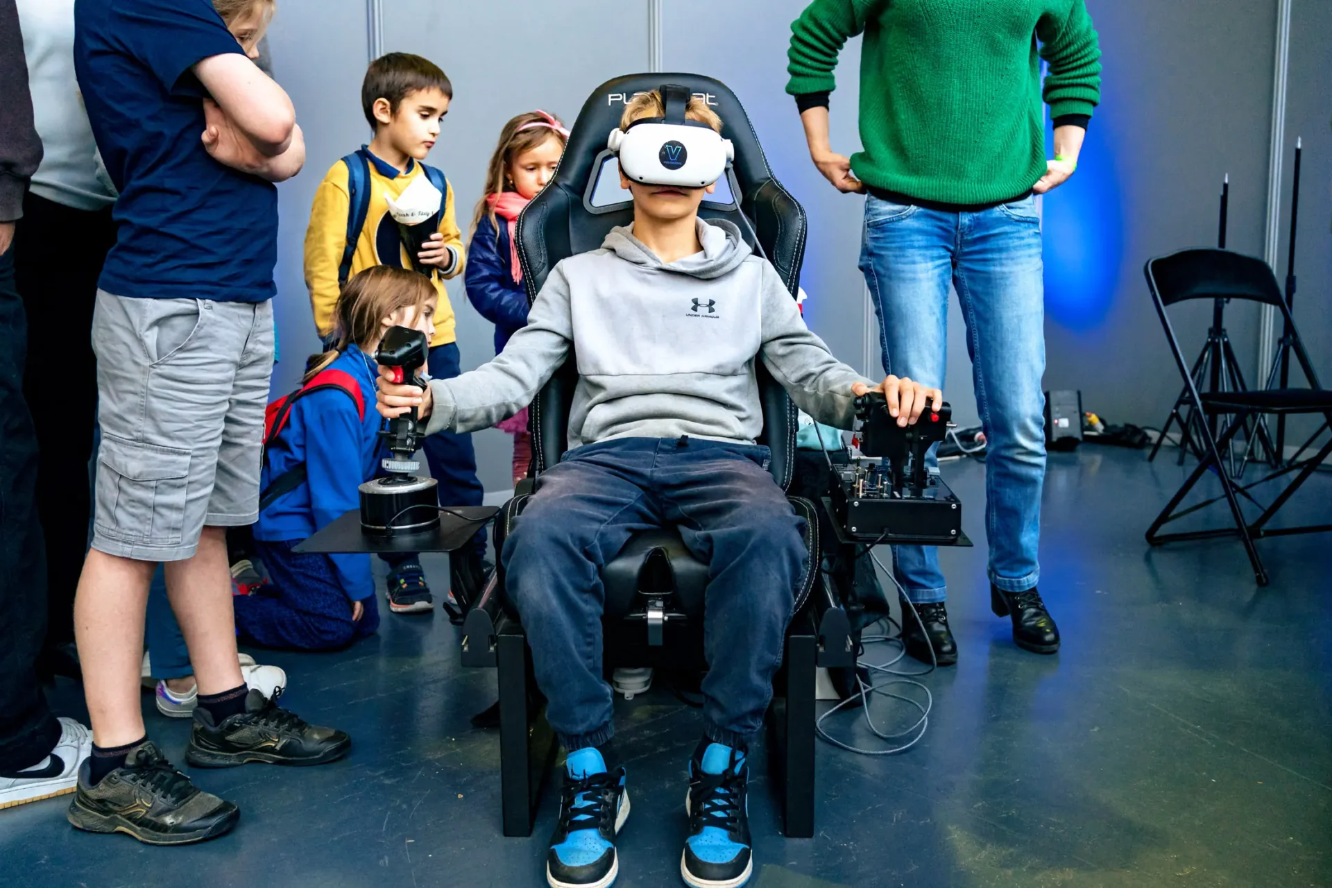 Un garçon dans un fauteuil de pilote d'avion avec des lunettes de réalité virtuelle au I love science festival à Bruxelles