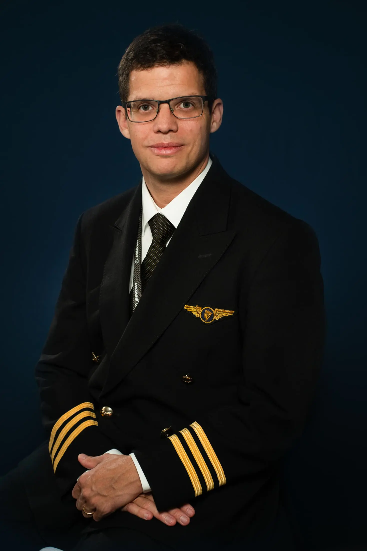 Portrait d'un pilote d'avion en uniforme sur fond bleu