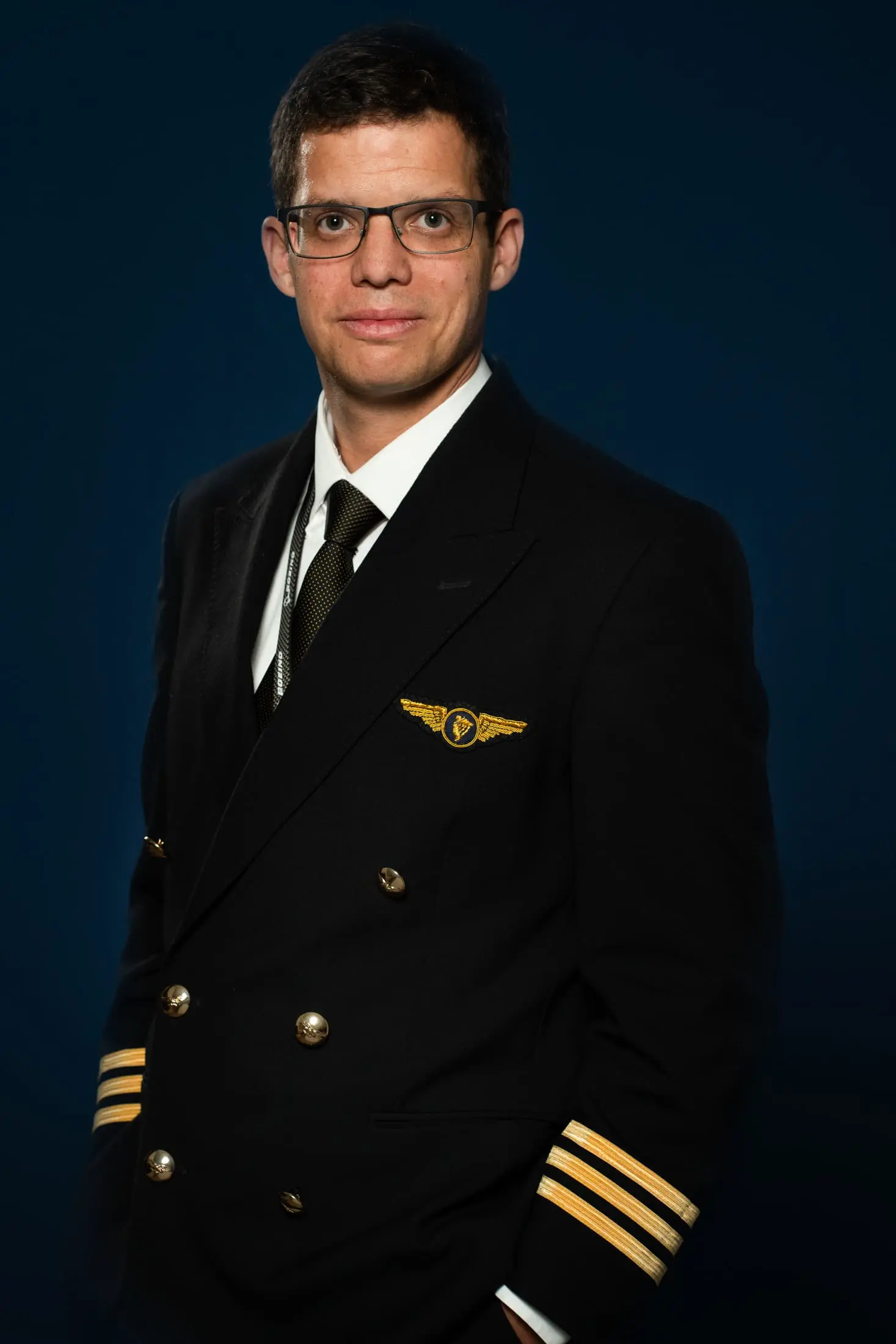 Portrait d'u pilote d'avion en uniforme sur fond bleu