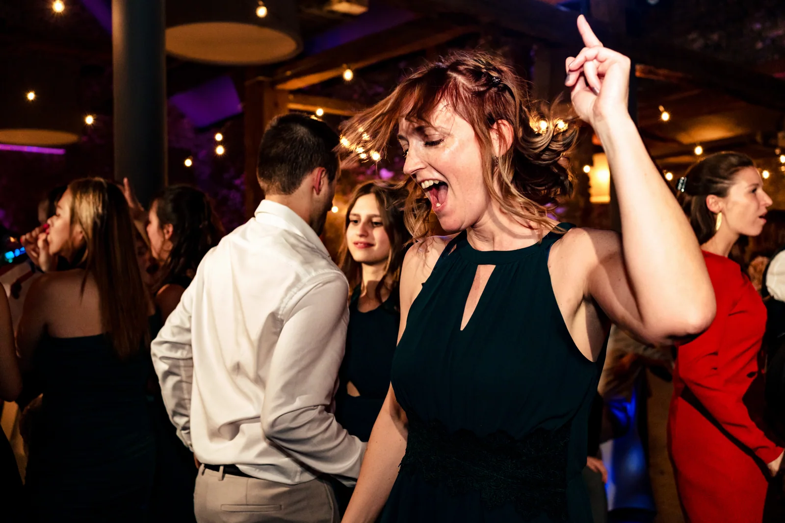 Une femme danse avec un bras en l'air lors d'une soirée d'entreprise photographié à Bruxelles