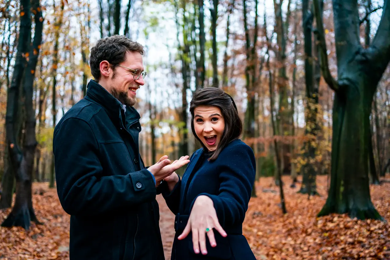 Une dame montrant sa bague de fiançailles au coté d'un homme dans le bois de la Cambre en automne à Bruxelles