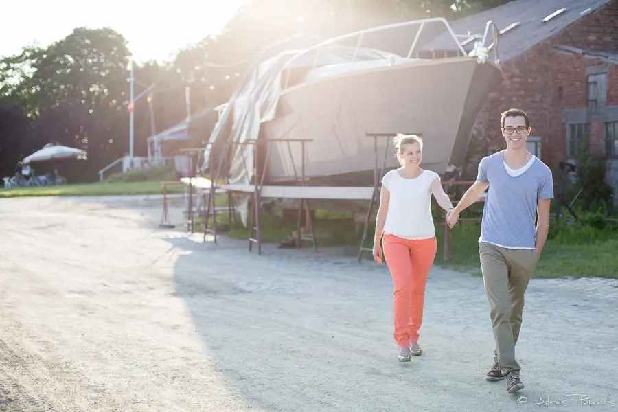 Un couple se promène à contre-jour dans un port de plaisance à Doel