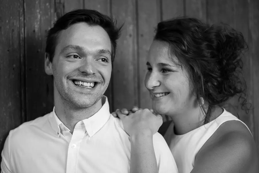 une femme est appuyé sur l'épaule d'un homme en chemise blanche lors d'une séance photo de couple