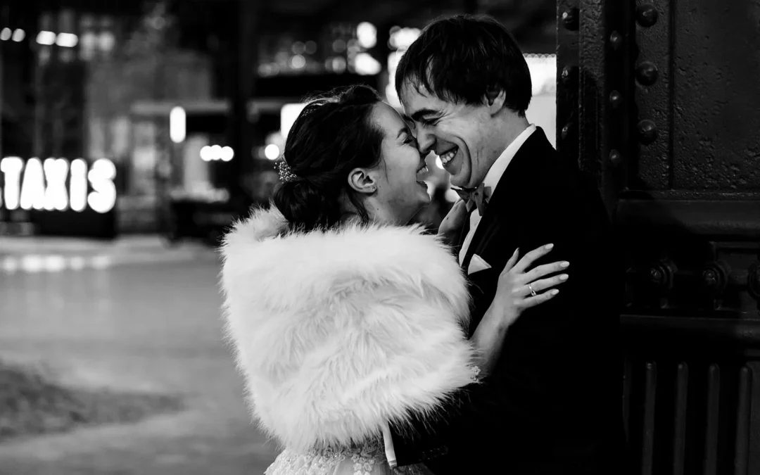 Un couple face a face éclatant de rire lors d'une session photo de couple durant leur mariage